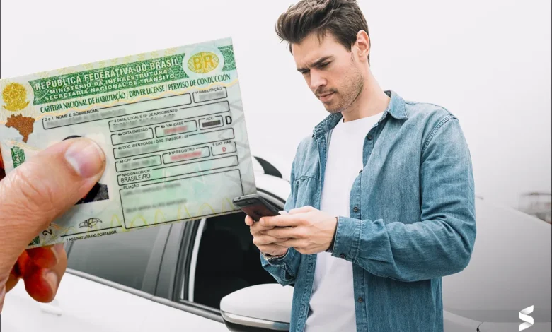 Jovem consulta informações sobre CNH gratuita usando o celular ao lado do carro
