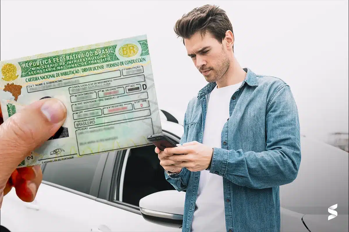 Jovem consulta informações sobre CNH gratuita usando o celular ao lado do carro