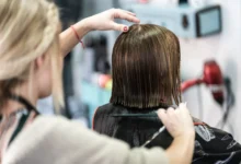 Cabeleireiro cortando cabelo curto de mulher em um salão de beleza, com foco em técnicas modernas de corte.