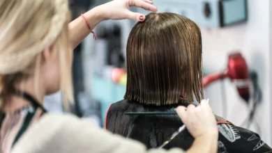 Cabeleireiro cortando cabelo curto de mulher em um salão de beleza, com foco em técnicas modernas de corte.