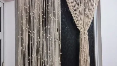 Cortina de crochê feita à mão com fios naturais e detalhes delicados, pendurada em uma janela.