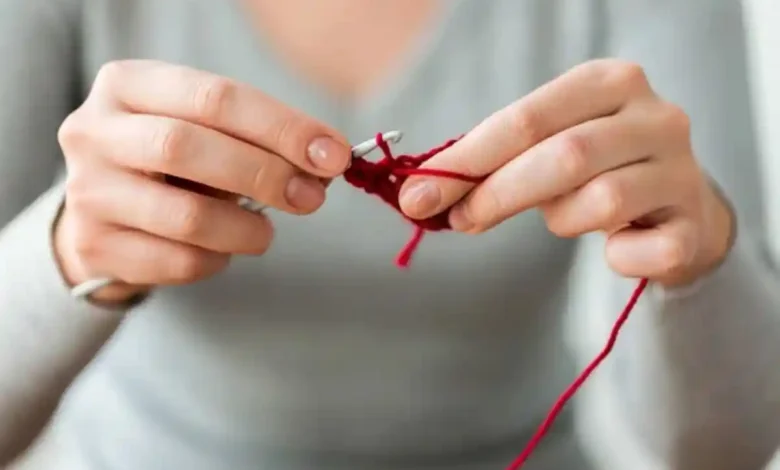 Pessoa praticando crochê avançado com linha vermelha