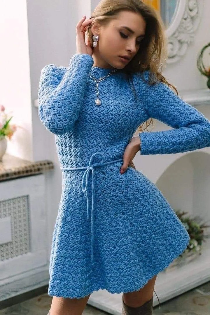 Vestido de crochê azul com mangas longas e cinto na cintura, perfeito para o inverno.