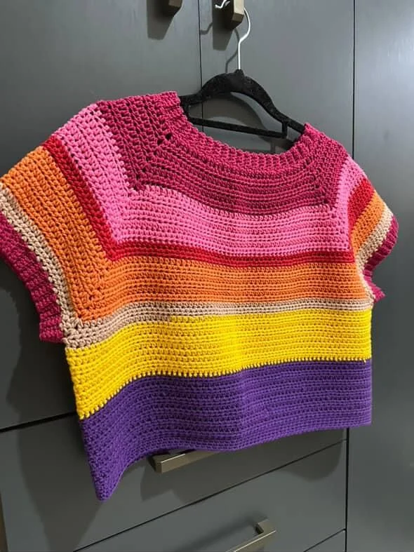 Blusa de crochê colorida com listras em tons vibrantes de rosa, laranja, amarelo e roxo