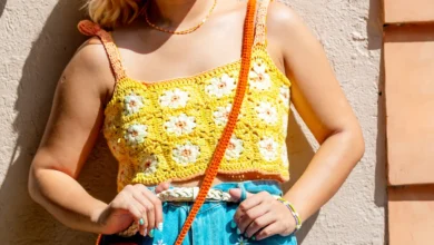 cropped de crochê Blusa de crochê amarela com flores coloridas, detalhes em laranja, e acessórios combinando em um look casual e vibrante.