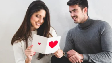 Casal sorrindo juntos no Dia dos Namorados, comemorando com um cartão de presente. Imagem representando presentes que dinheiro não compra.