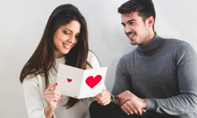 Casal sorrindo juntos no Dia dos Namorados, comemorando com um cartão de presente. Imagem representando presentes que dinheiro não compra.