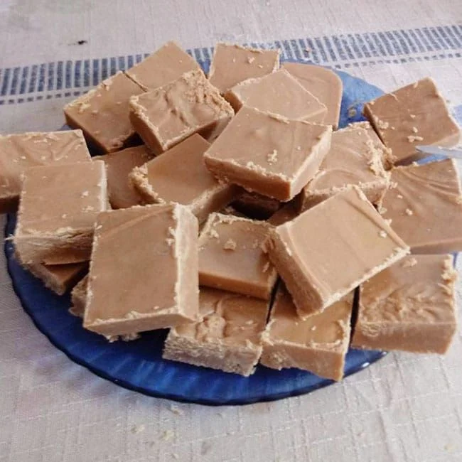 Quadrados de doce de leite de corte em uma travessa, com textura crocante e macia.