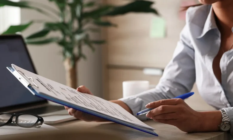 Mulher preenchendo formulário com documentos em escritório, representando os papéis exigidos para o Minha Casa Minha Vida 2025