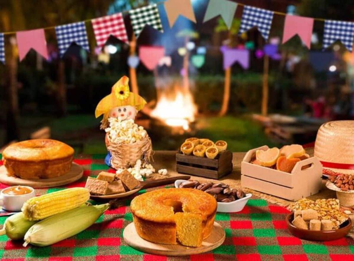 Variedade de comidas típicas de festa junina saudável, incluindo bolo, milho, doces e pipoca.