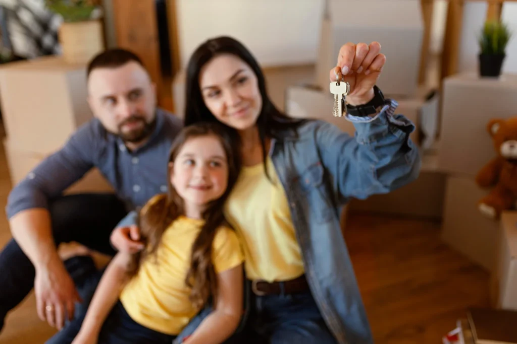 Família feliz segurando chaves de sua nova casa, simbolizando a conquista do sonho da casa própria