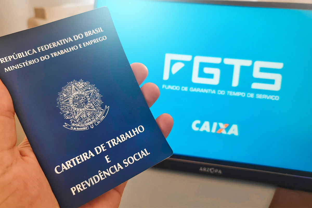Carteira de Trabalho e tela com logo do FGTS, representando o uso do fundo no Minha Casa Minha Vida