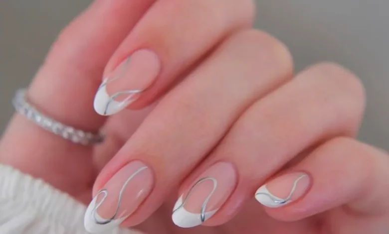 Unhas com tendência de francesinha invertida com detalhes prateados, estilo moderno e minimalista para 2025.