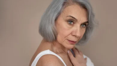 Mulher com cabelo grisalho em estilo moderno, refletindo a tendência da moda dos grisalhos, aos 50 anos.