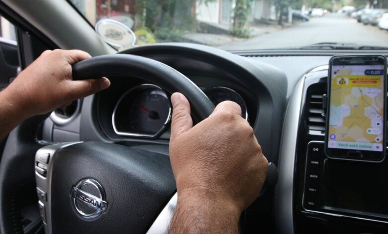 Motorista com app da Uber aberto no painel do carro, pronto para iniciar atendimento