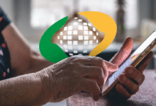 Imagem mostrando mãos de uma pessoa idosa usando um celular, com sobreposição de um ícone representando o INSS, indicando que os pagamentos serão antecipados em junho devido ao feriado.