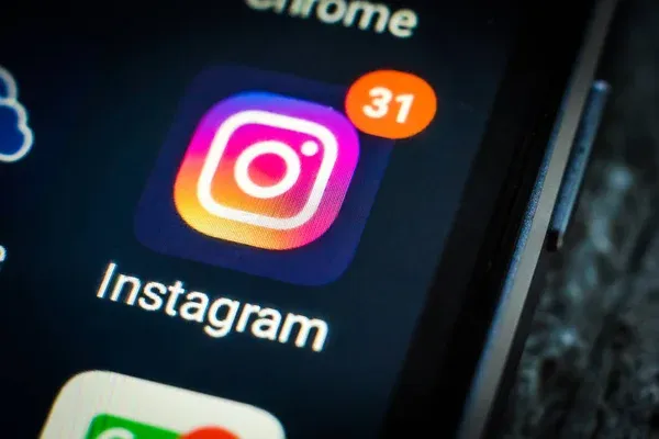 Imagem do ícone do Instagram em um smartphone, com notificação de 31 mensagens, representando a plataforma de redes sociais.