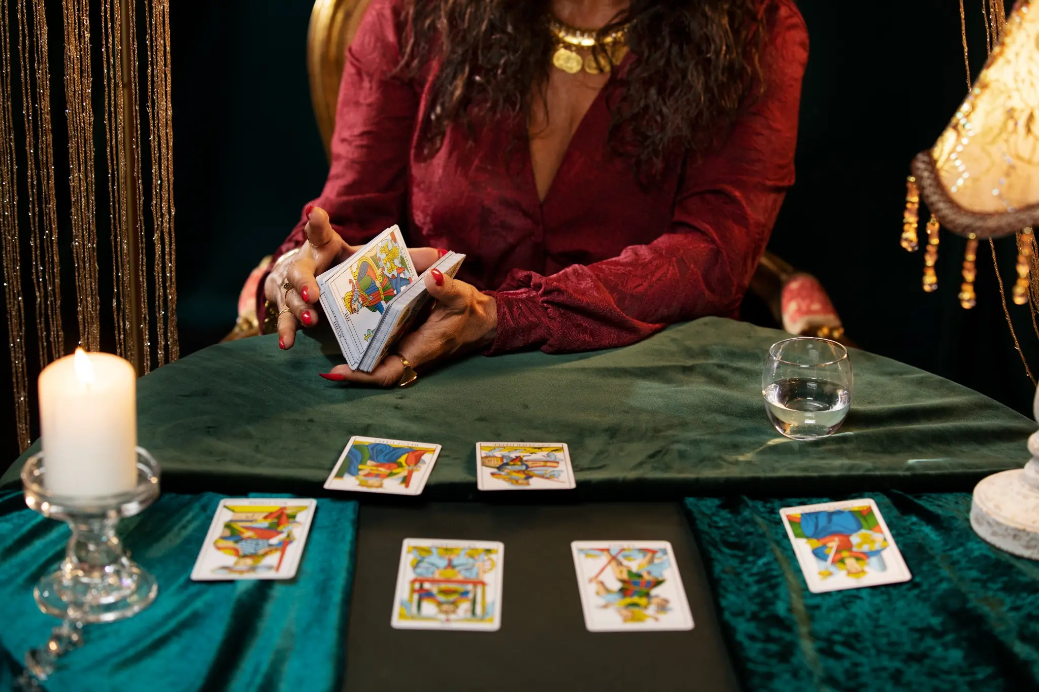 Mulher realiza leitura do Baralho Cigano com cartas dispostas sobre a mesa