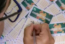 Pessoa preenchendo bilhete da Mega-Sena, com vários bilhetes ao fundo