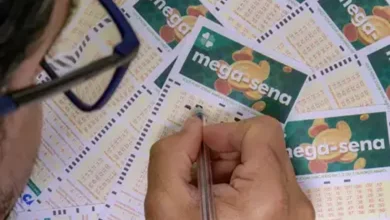 Pessoa preenchendo bilhete da Mega-Sena, com vários bilhetes ao fundo
