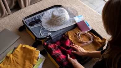 Mulher organizando mala de viagem com roupas, acessórios e itens essenciais