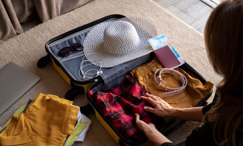 Mulher organizando mala de viagem com roupas, acessórios e itens essenciais