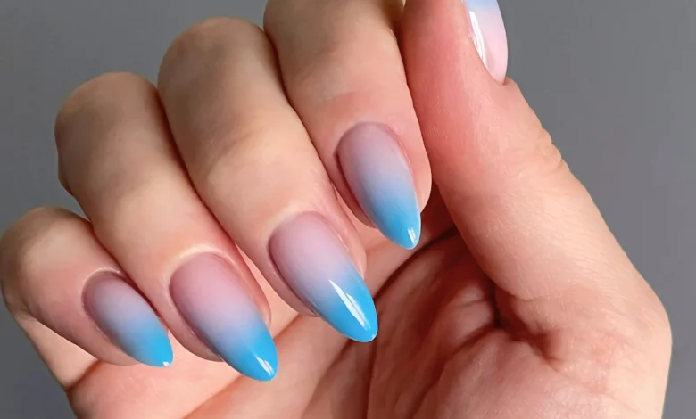 Unhas decoradas com esmalte degradê azul, manicure elegante e moderna.