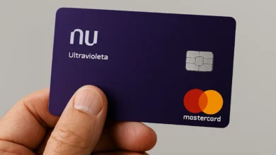 Mão idosa segurando cartão de crédito Nubank Ultravioleta.