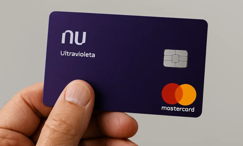 Mão idosa segurando cartão de crédito Nubank Ultravioleta.