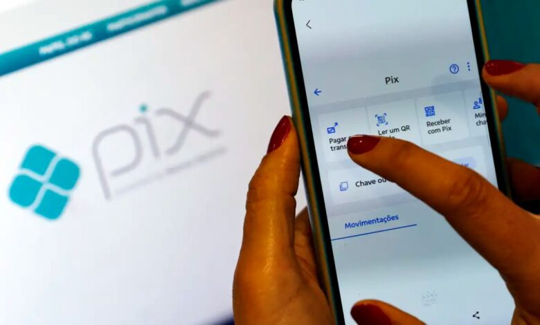 Pessoa acessando o menu do Pix no aplicativo do banco pelo celular com destaque para a função de pagamento