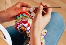 Mulher crochetando peça colorida com agulha de crochê