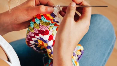Mulher crochetando peça colorida com agulha de crochê