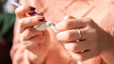 Mulher fazendo crochê com fio branco, usando técnica para criar texturas