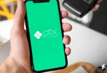 Pessoa usando o Pix em um smartphone com a tela verde exibindo o logo do Banco Central.