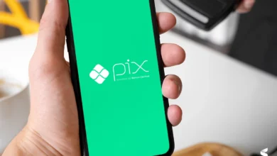 Pessoa usando o Pix em um smartphone com a tela verde exibindo o logo do Banco Central.