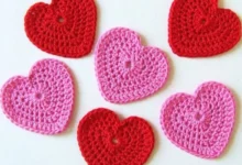 Corações de crochê em tons de vermelho e rosa, feitos à mão para o Dia dos Namorados.