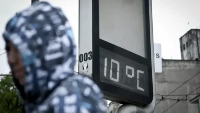 Termômetro marcando 10 graus Celsius em rua urbana no início do inverno.