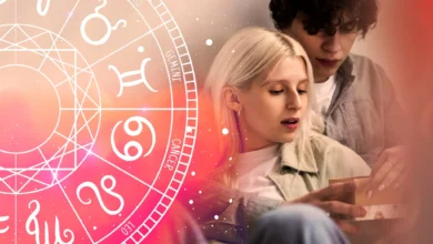 Casal jovem lendo previsões amorosas com roda zodiacal ao fundo