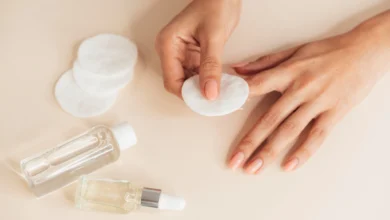 Mãos femininas com unhas cuidadas usando algodão para remover esmalte sem acetona