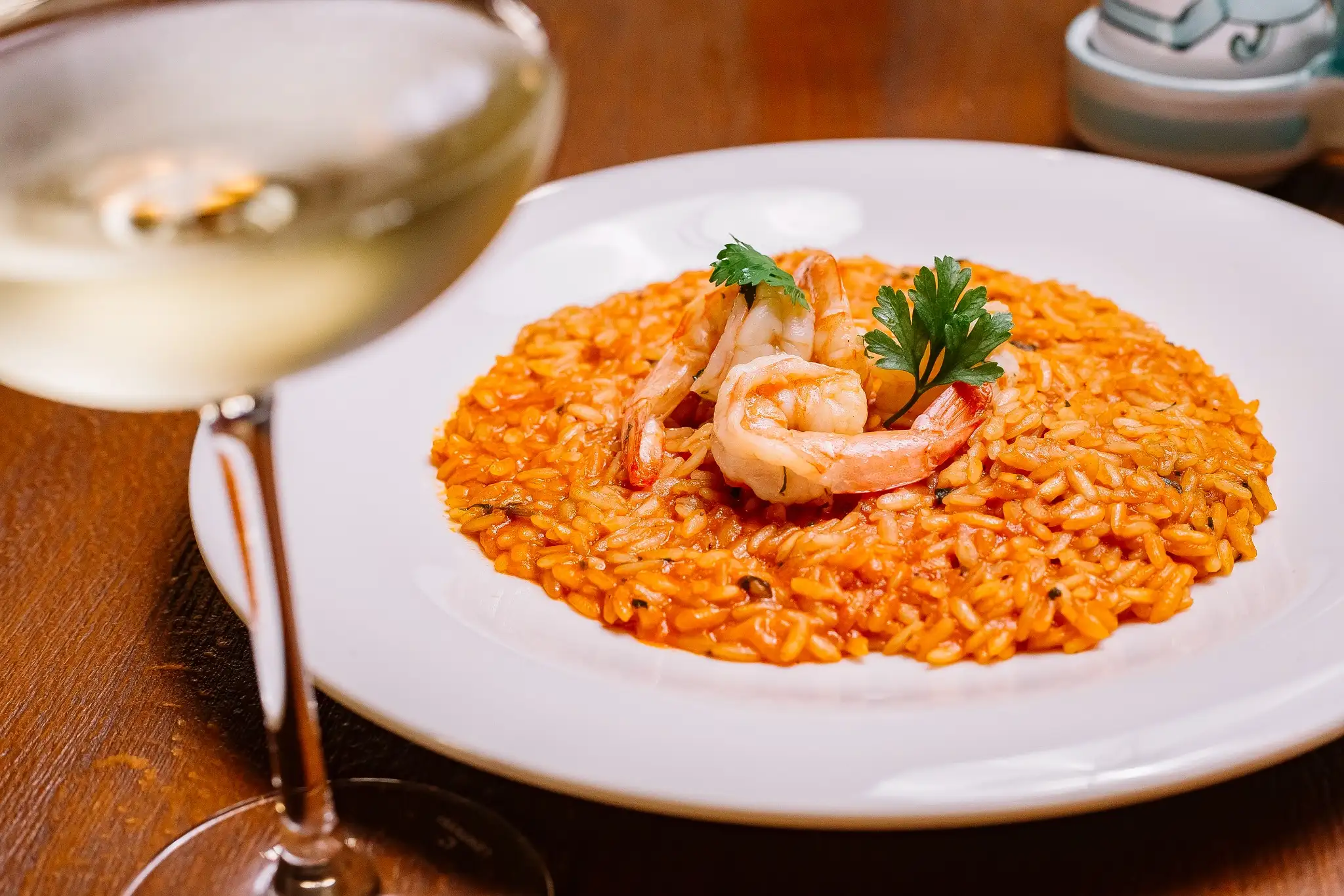 Prato de risoto de camarão servido com vinho branco para jantar romântico