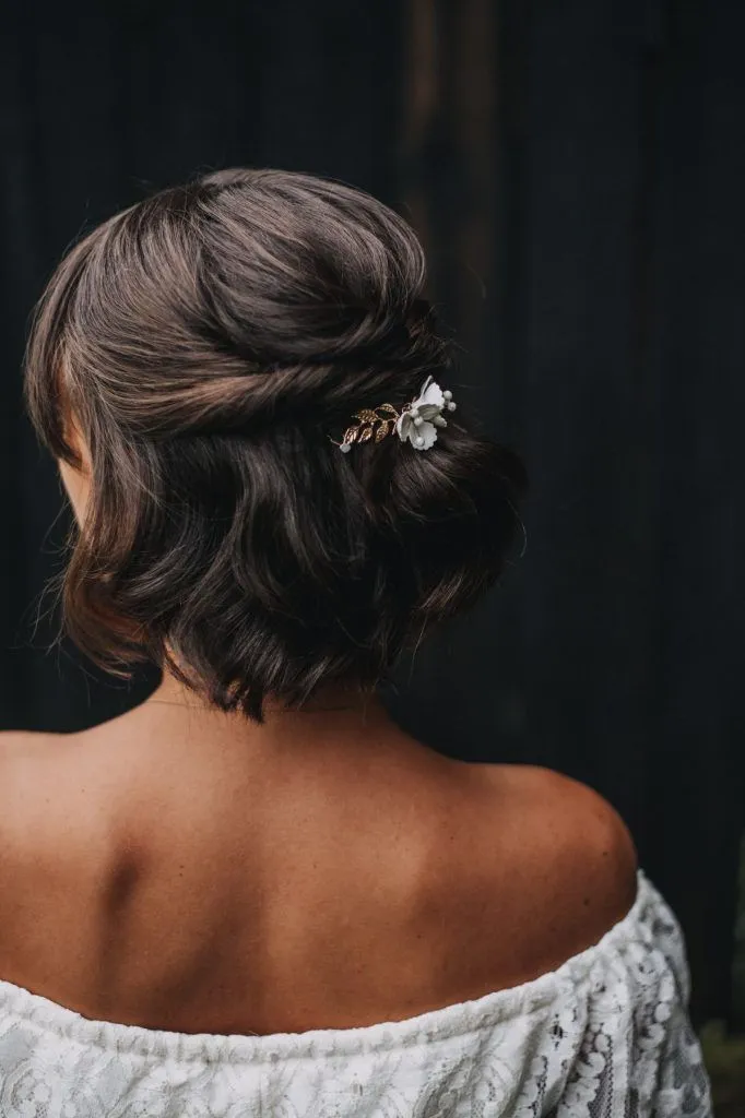 Mulher com cabelo semi-preso decorado com acessórios, elegante e charmoso.
