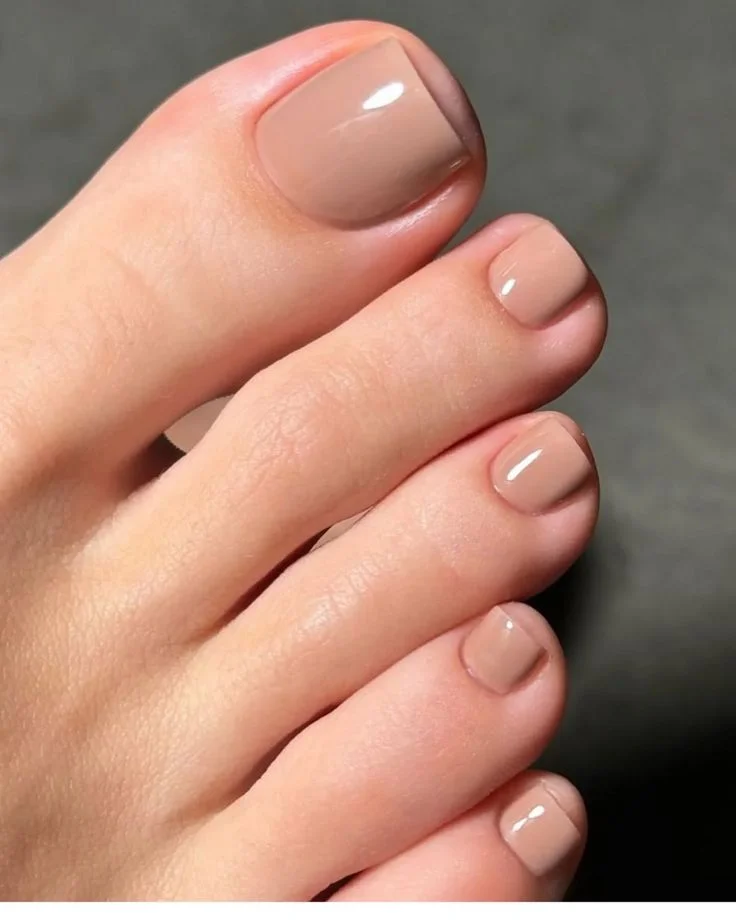 Unhas dos pés com esmalte nude clássico