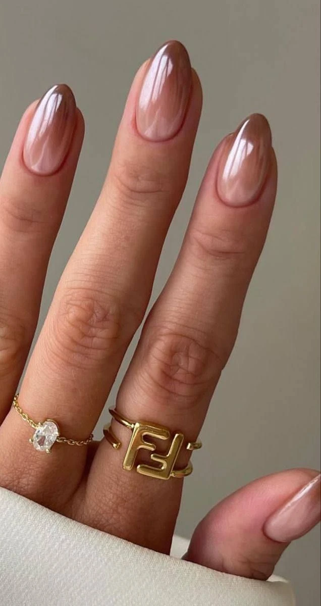Unhas decoradas com esmalte nude e marrom em degradê com acabamento brilhante.