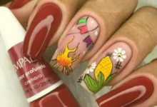 Unhas decoradas para festa junina com fogueira, bandeirinhas e espiga de milho.