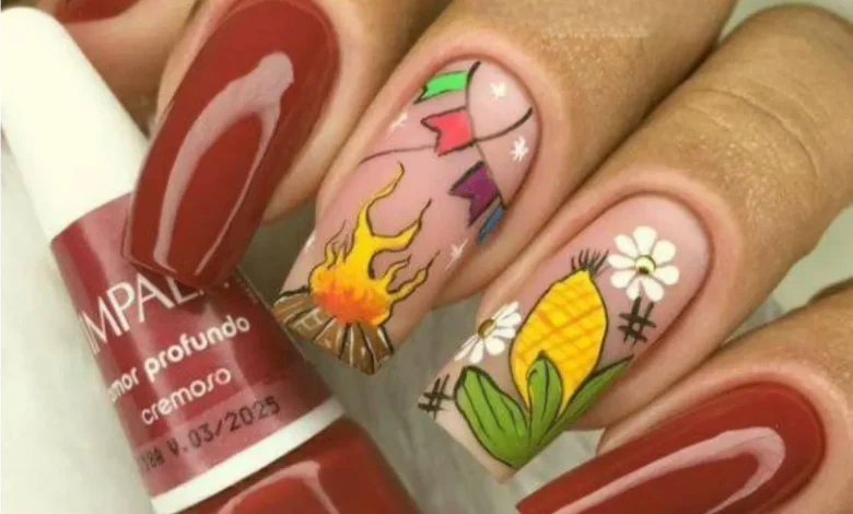 Unhas decoradas para festa junina com fogueira, bandeirinhas e espiga de milho.