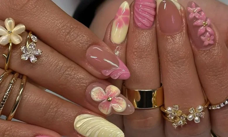 Unhas em 3D: Arte delicada com flores e texturas, cores suaves de rosa e amarelo.