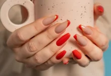 Unhas com cores e acabamentos modernos: esmalte vermelho e nude com ponta dourada, perfeitas para rejuvenecer as mãos.
