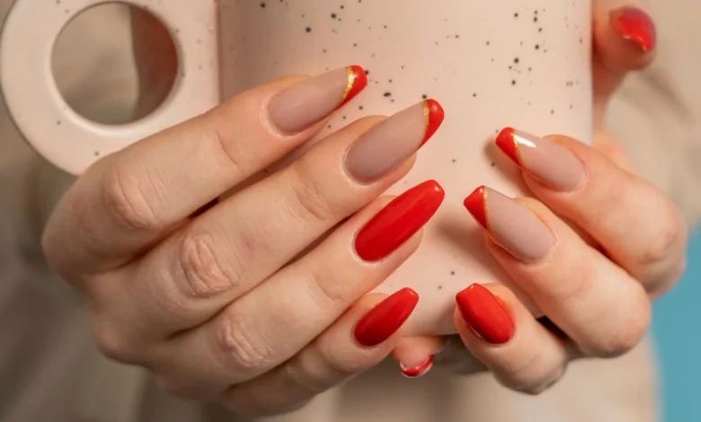 Unhas com cores e acabamentos modernos: esmalte vermelho e nude com ponta dourada, perfeitas para rejuvenecer as mãos.