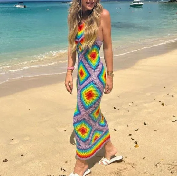 Vestido longo de crochê colorido com padrões de arco-íris na praia.