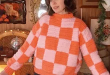 Suéter de crochê laranja e rosa com estampa xadrez em um look de inverno moderno